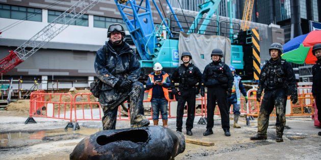 TOPSHOT - Bomb disposal expert Adam Roberts (L) rests his foot on a defused US-made bomb dropped during World War II a day after it was discovered on a harbourfront construction site in the Wan Chai district of Hong Kong on February 1, 2018. 


A wartime bomb was defused in Hong Kong on February 1 after a busy commercial district went into lockdown, with roads closed and thousands evacuated from surrounding shops, hotels and offices.   / AFP PHOTO / Anthony WALLACE        (Photo credit should read ANTHONY WALLACE/AFP/Getty Images)