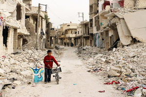 A Syrian boy walks with his bicycle in the devastated Sukari district in the northern city of Aleppo on November 13, 2014, after more than three years of fighting and shelling. Syrians are increasingly unable to escape their country's war as tougher policies in potential host nations are preventing them from taking refuge in the region and beyond. AFP PHOTO / BARAA AL-HALABI        (Photo credit should read BARAA AL-HALABI/AFP/Getty Images)