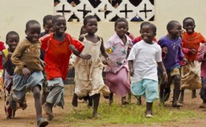 Malawi, Mzimba district, Chilumba Community Based Childcare Centres (CBCC). children running in front of building
