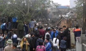 Villagers look at the site where a big explosion razed five homes and shattered windows of surrounding buildings in the northern province of Bac Ninh on January 3, 2018. A baby and five-year-old girl were killed in the explosion that destroyed several houses east of Vietnam's capital Hanoi early on January 3, leaving at least six other people in hospital. / AFP PHOTO / HOANG DINH NAM